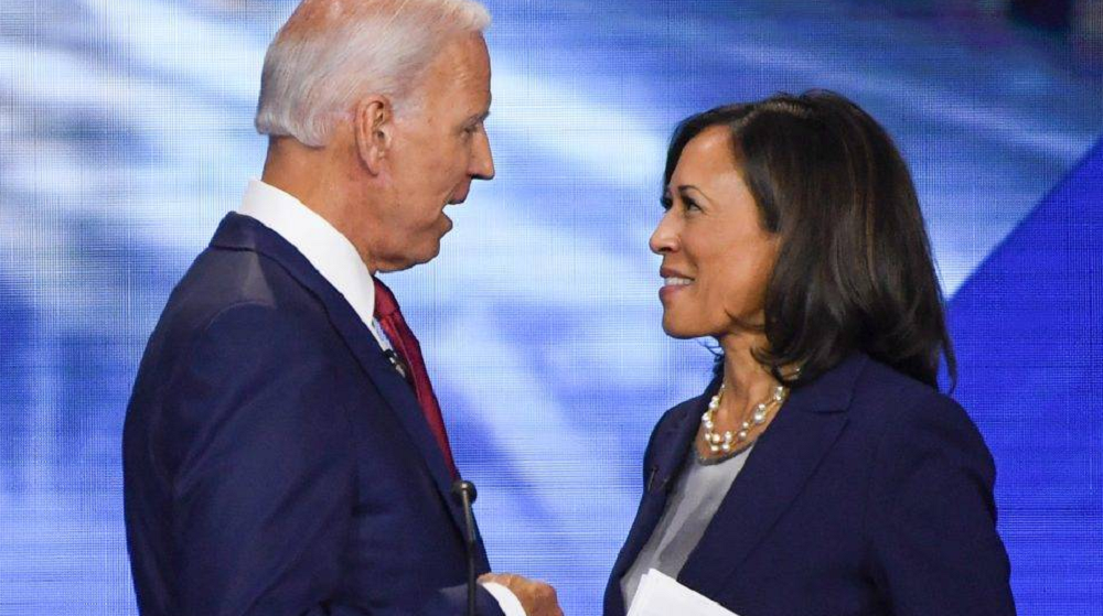 Joe Biden e Kamala Harris se olhando e sorrindo