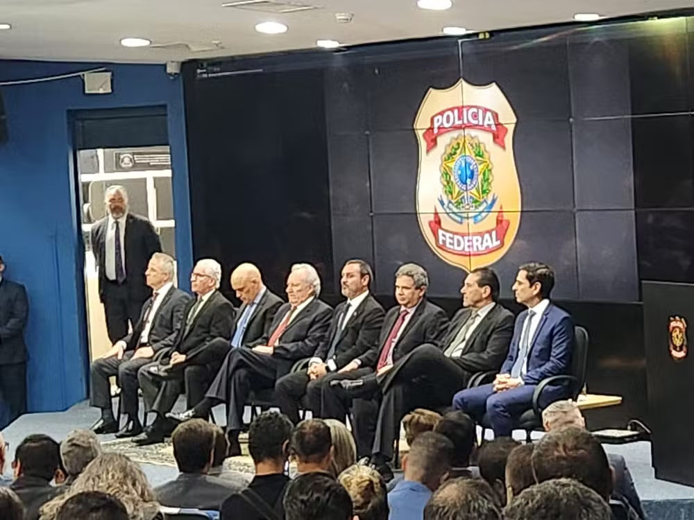 Posse do novo superintendente da PF em São Paulo, Rodrigo Sanfurgo, com autoridades sentadas lado a lado e logo da PF atrás