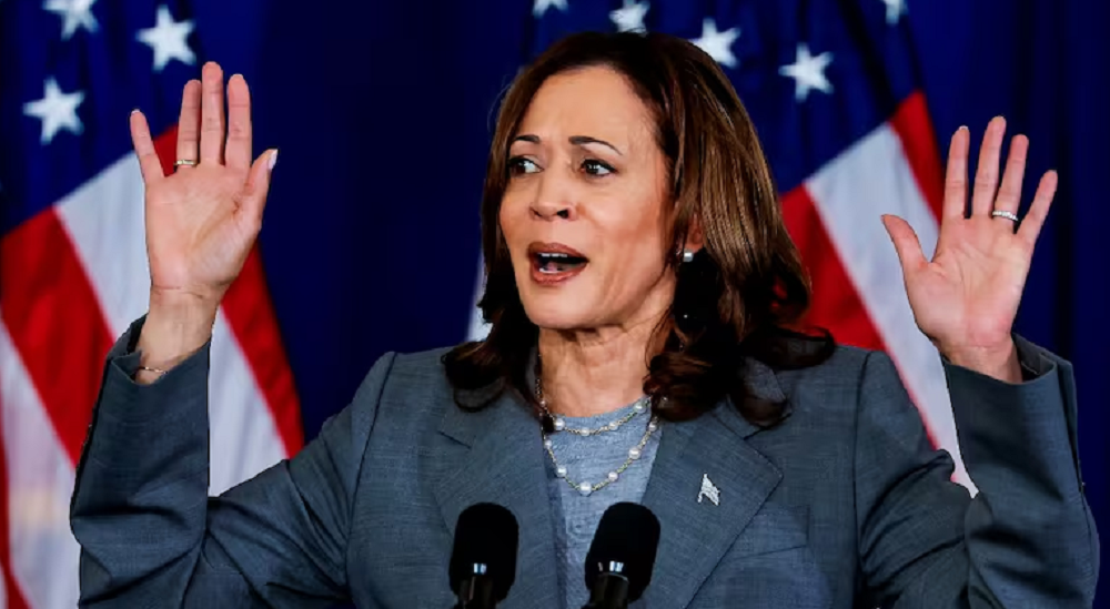 A vice-presidente dos Estados Unidos, Kamala Harris, com expressão assustada, perto de bandeira norte-americana