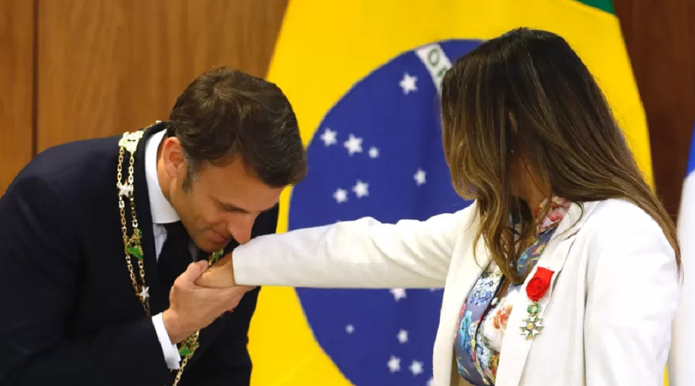 O presidente francês Emmanuel Macron cuprimentando a primeira-dama do Brasil, Janja, beijando a mão dela