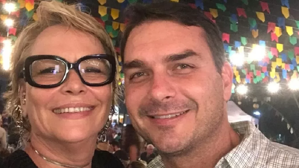 Rogéria Nantes com o filho Flávio Bolsonaro, senador pelo Rio de Janeiro, ambos sorrindo lado a lado