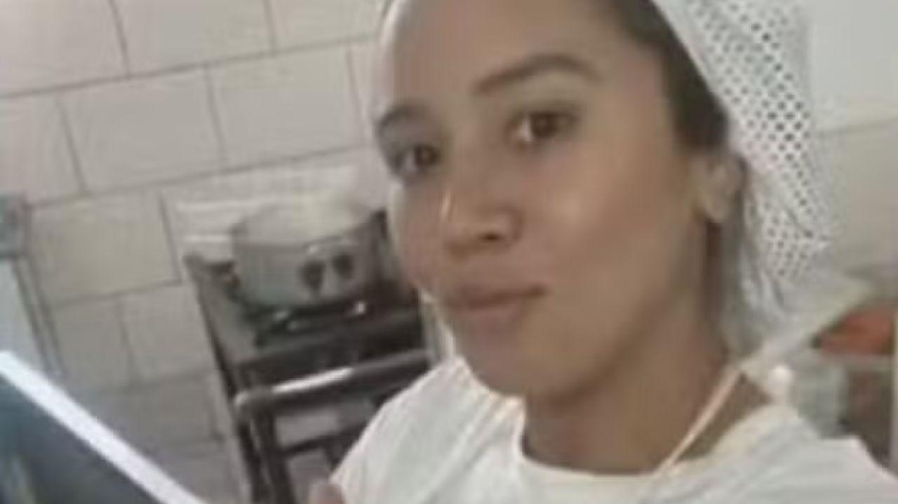 A merendeira Priscila Araújo Barbosa, de uniforme branco, posando para selfie sem sorrir