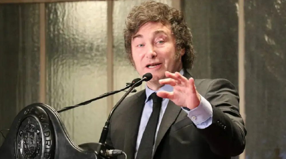 O presidente da Argentina, Javier Milei, falando em microfone, olhando para o lado e apontando pra frente