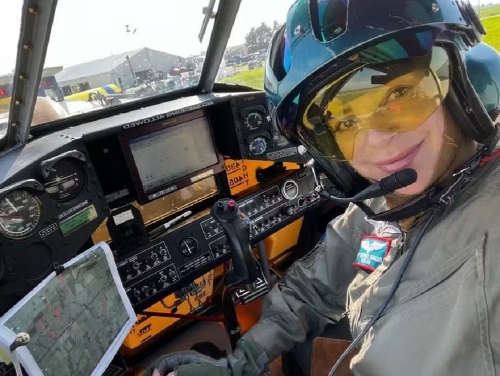 Juliana Turchetti posando dentro de avião, com sorriso tímido, equipada