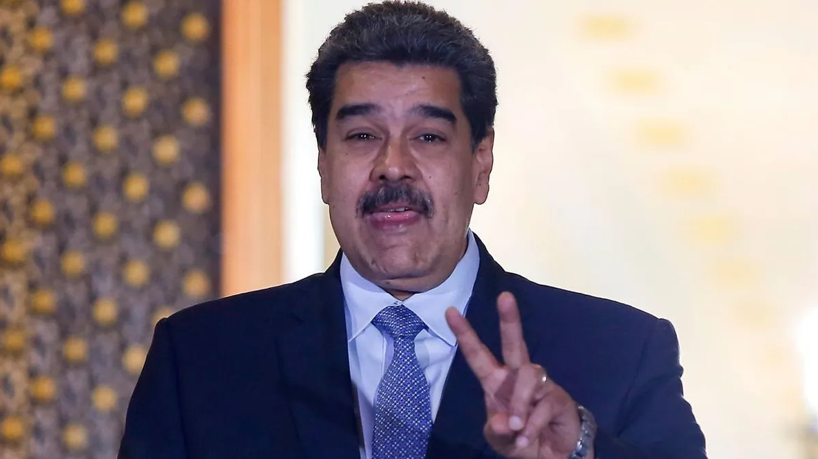 Nicolás Maduro falando e fazendo sinal de paz e amor