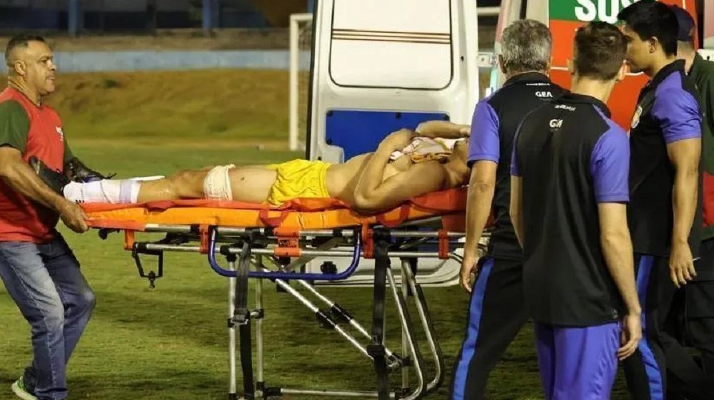 Momento em que Ramón Souza é retirado do campo de maca, perto de ambulância