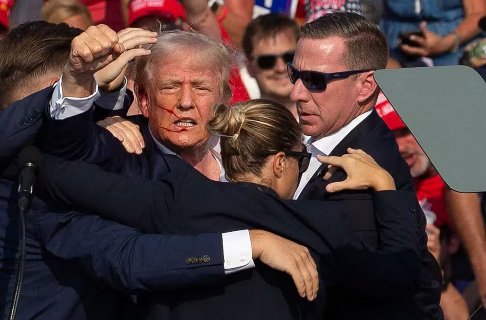 Donald Trump após ser baleado durante comício na Pensilvânia, cercado por seguranças