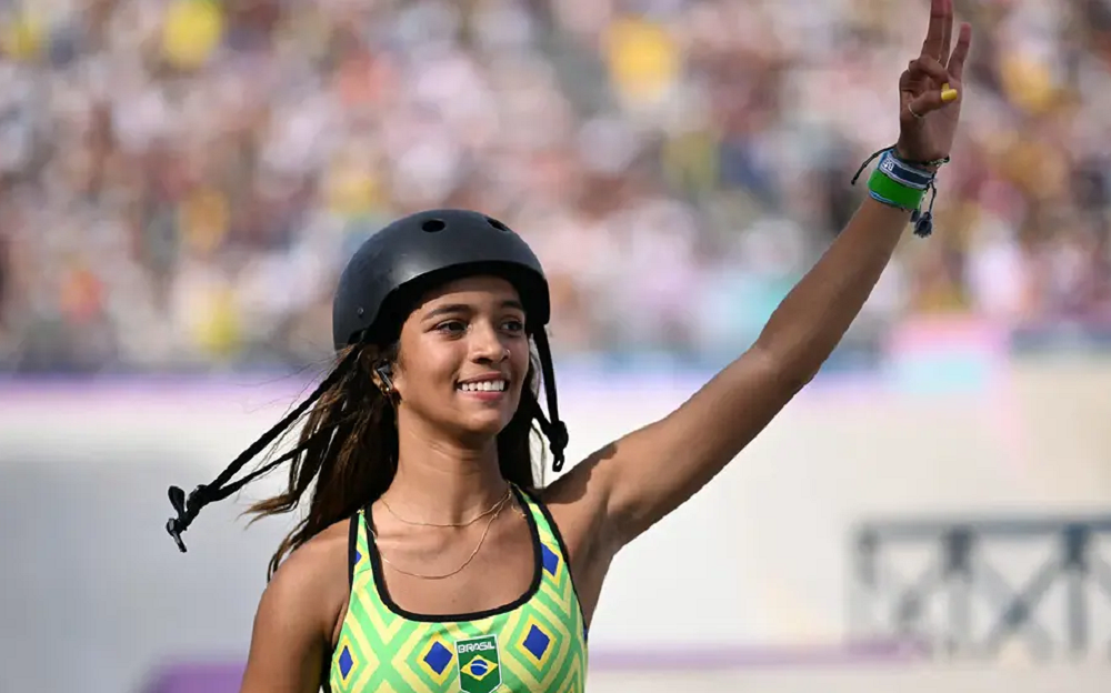 Rayssa Leal sorrindo e acenando na Olimpíada de Paris, de capacete