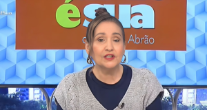 Sonia Abrão no A Tarde é Sua desta sexta-feira (19), de roupa de frio azul e cinza, de coque, falando para a câmera com expressão séria