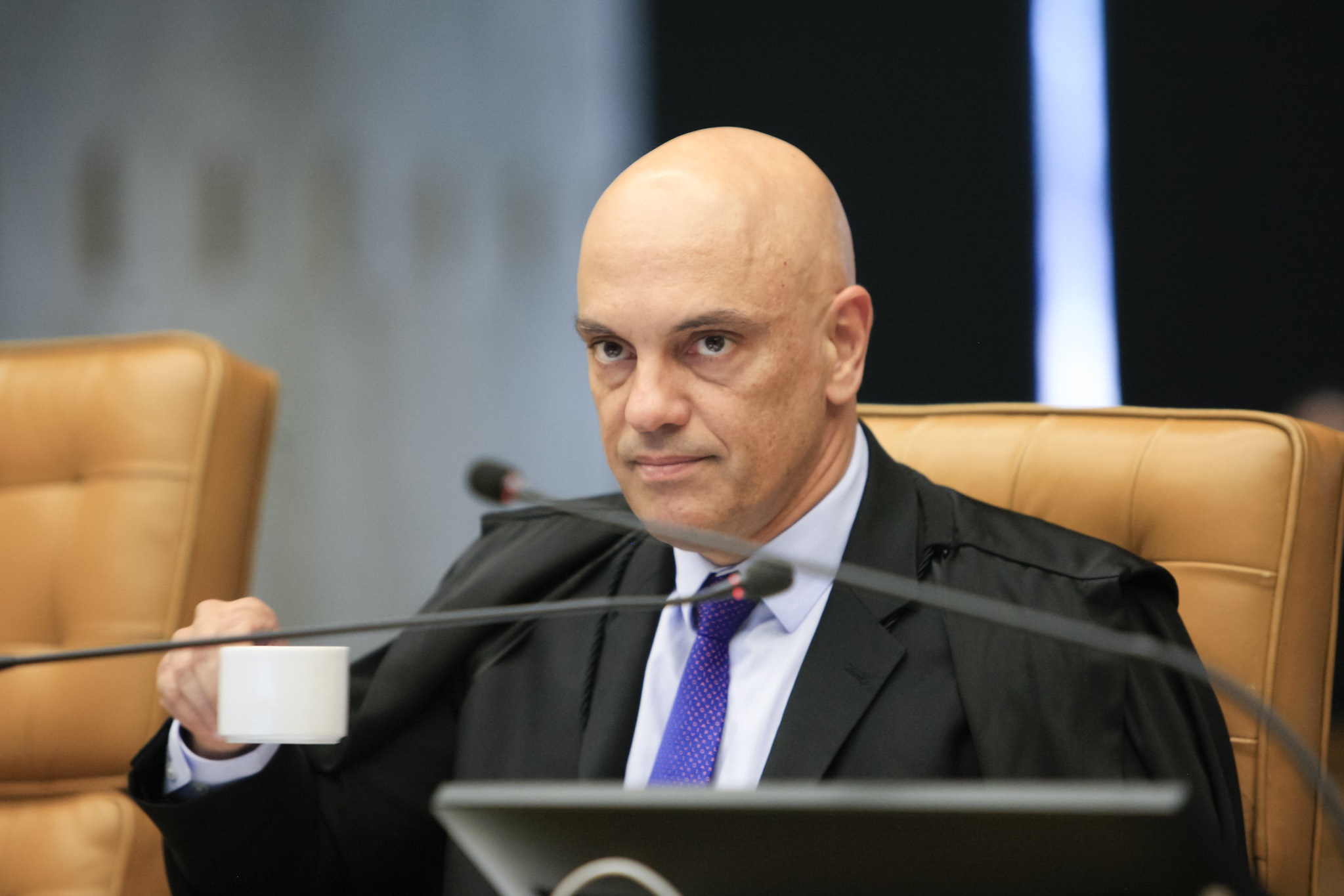 O ministro Alexandre de Moraes, do Supremo Tribunal Federal (STF), sem olhar para a câmera, sério, segurando xícara branca