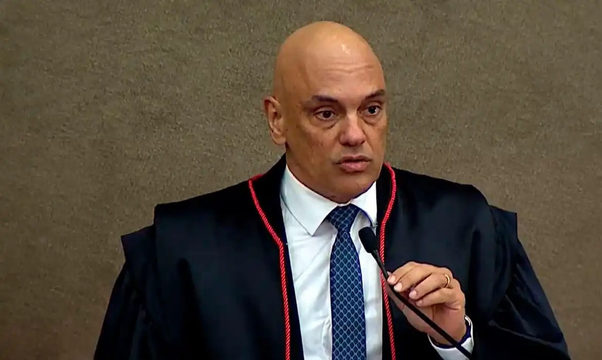 ministro do Supremo Tribunal Federal (STF), Alexandre de Moraes segurando microfone com expressao seria, sem olhar para a camera