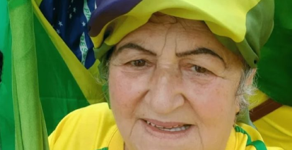 Maria de Fátima Mendonça Jacinto, conhecida como “Fátima de Tubarão”, vestida com as cores da bandeira do Brasil, sem sorrir, olhando para a câmera, em close