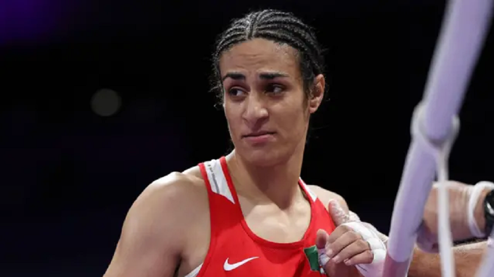A boxeadora argelina Imane Khelif com expressão séria, sem olhar para a câmera