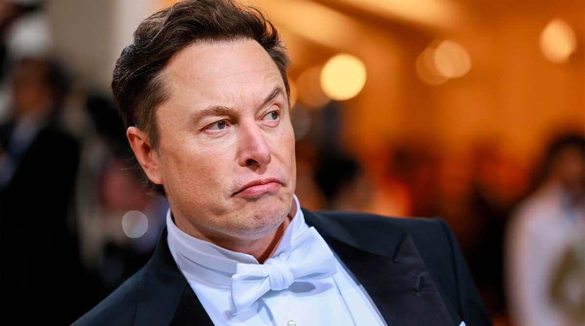 Elon Musk com expressão de insatisfação, olhando para o lado