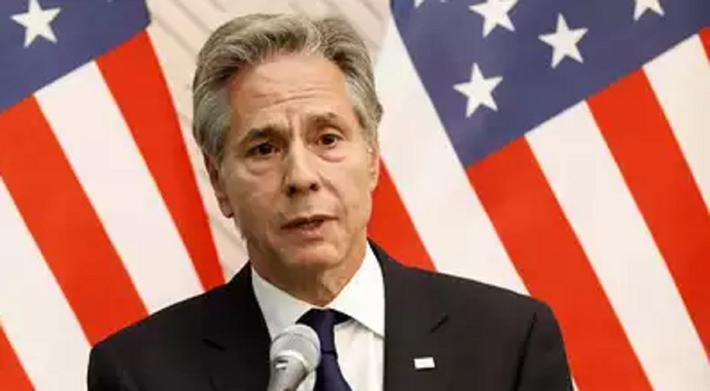 O secretário de Estado dos Estados Unidos (EUA), Antony Blinken, falando com expressão séria, com bandeira dos EUA atrás