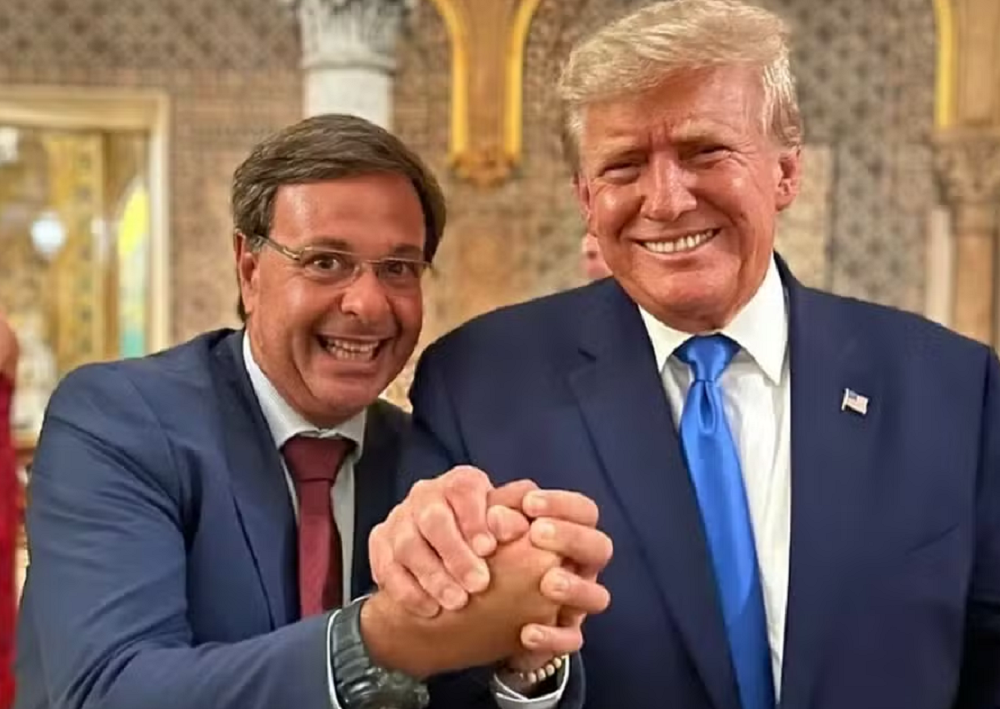 Gilson Machado (PL) posando com Donald Trump, ambos sorrindo de mãos dadas