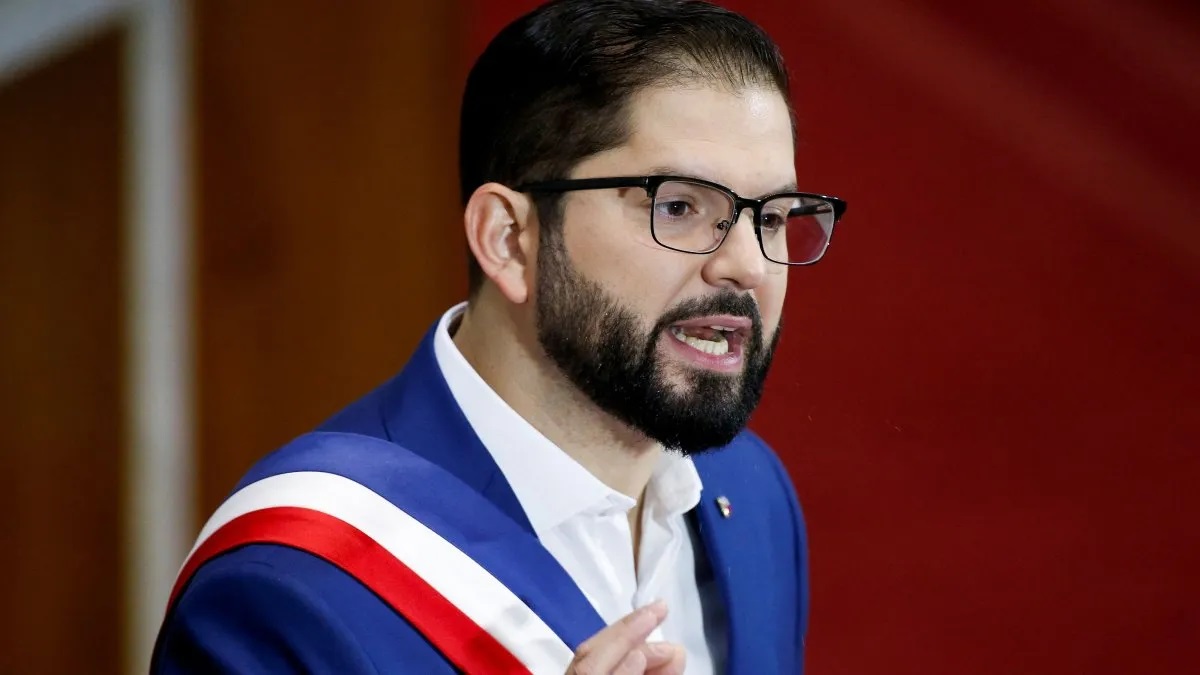 O presidente do Chile, Gabriel Boric, falando, de óculos, sem olhar para a câmera