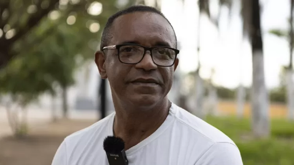 Osvanir Santana, um dos passageiros do ônibus assaltado pelo ex-cabo do Exécito Celio da Silva Cabral, em 1995, de roupa branca e óculos, sério