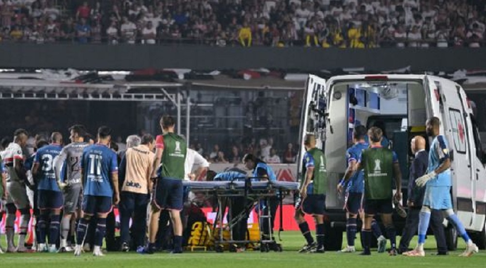 Momento em que o zagueiro Juan Izquierdo foi colocado na ambulância com outros jogadores em volta