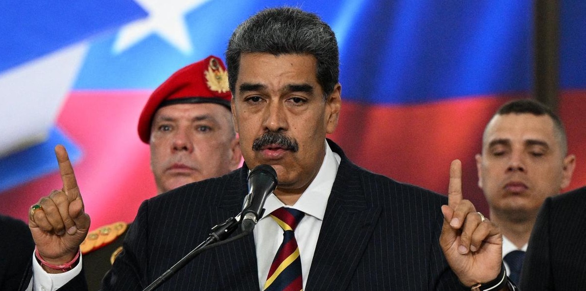 O presidente da Venezuela, Nicolás Maduro, falando em microfone e apontando pra cima com as duas mãos