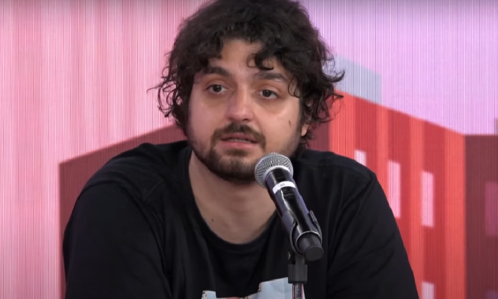 Monark sério, perto de microfone, de camiseta preta