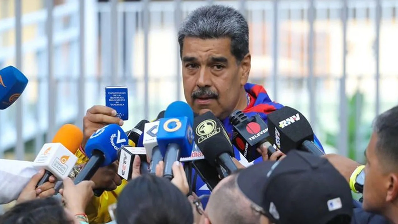 Nicolás Maduro em coletiva, falando para vários microfones, sério