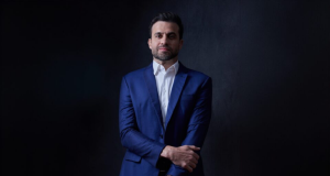 Pablo Marçal, candidato do PRTB à prefeitura de São Paulo, posando com sorriso tímido, de roupa social azul escura