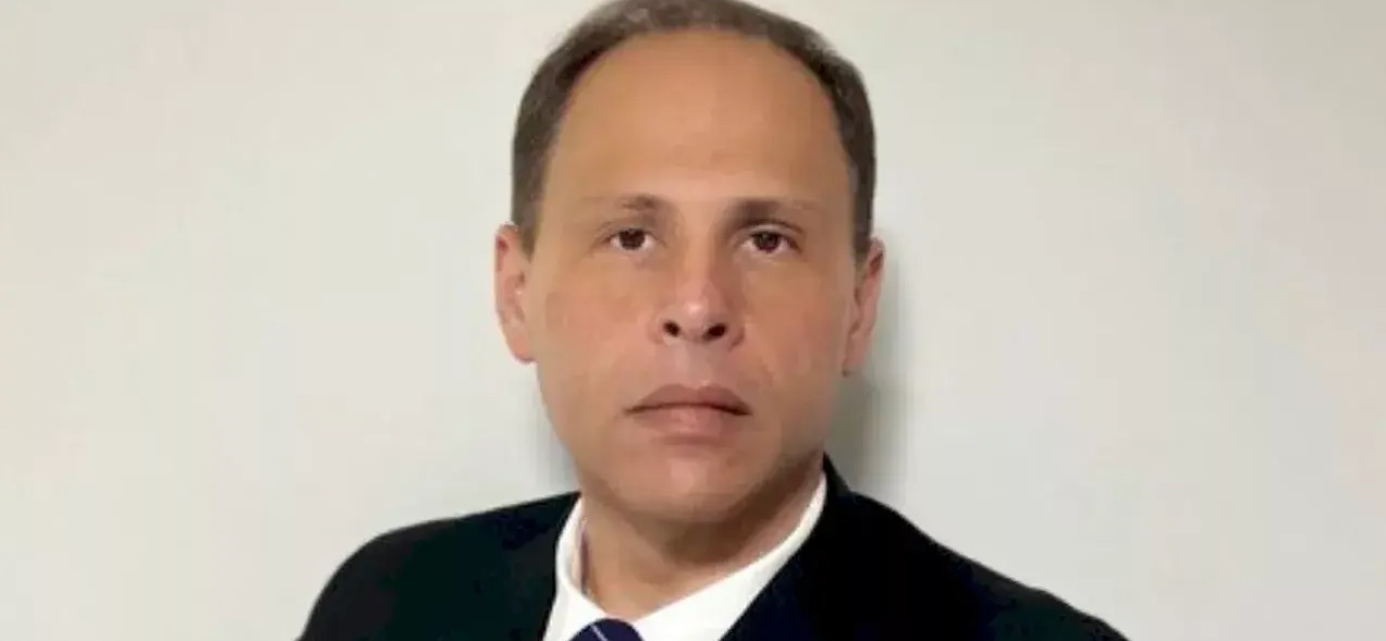 Eduardo Tagliaferro, ex-chefe da Assessoria Especial de Enfrentamento à Desinformação (AEED) do Tribunal Superior Eleitoral (TSE), sério, olhando para a câmera, em fundo cinza