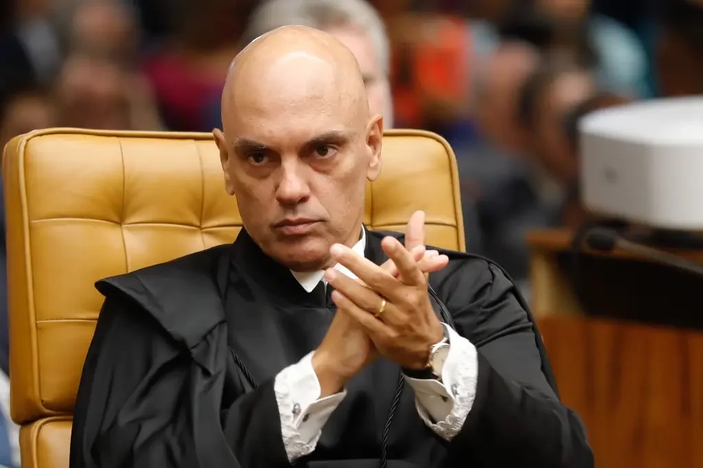 O ministro do Supremo Tribunal federal (STF) Alexandre de Moraes sério, batendo palmas, de preto, sem olhar para a câmera