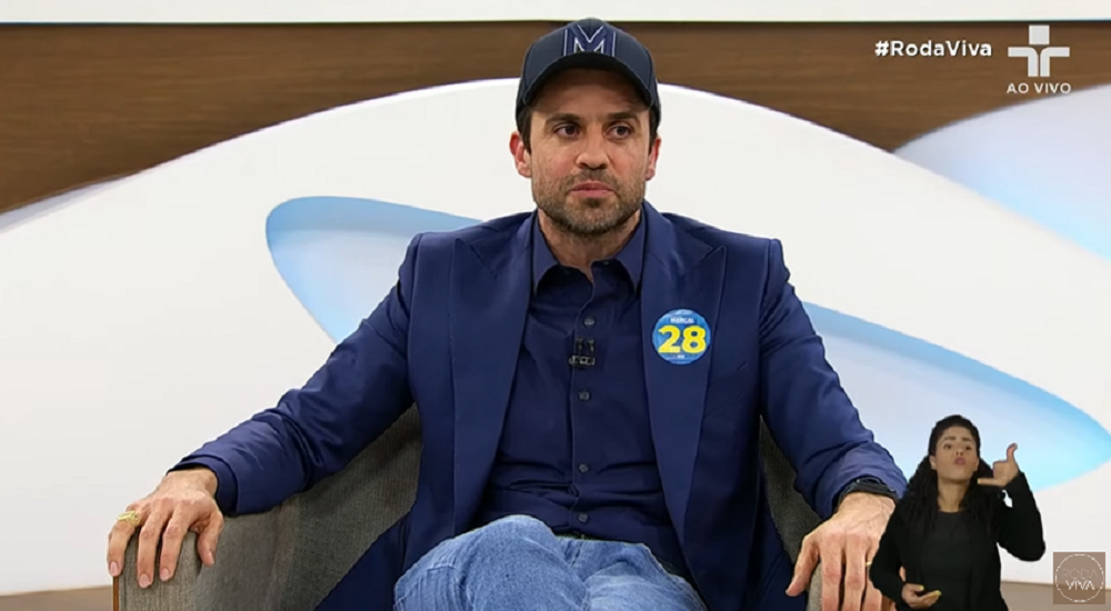 Pablo Marçal (PRTB) no Roda Viva, sentado, sério, de boné, olhando para o lado