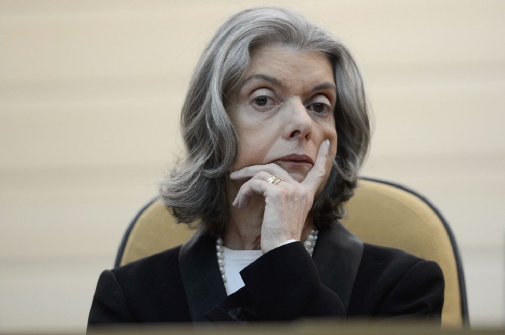A ministra Cármen Lúcia, presidente do Tribunal Superior Eleitoral (TSE), com expressão séria e mão no queixo
