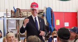 O presidente dos Estados Unidos, Joe Biden, usando um boné do ex-presidente Donald Trump, sorrindo