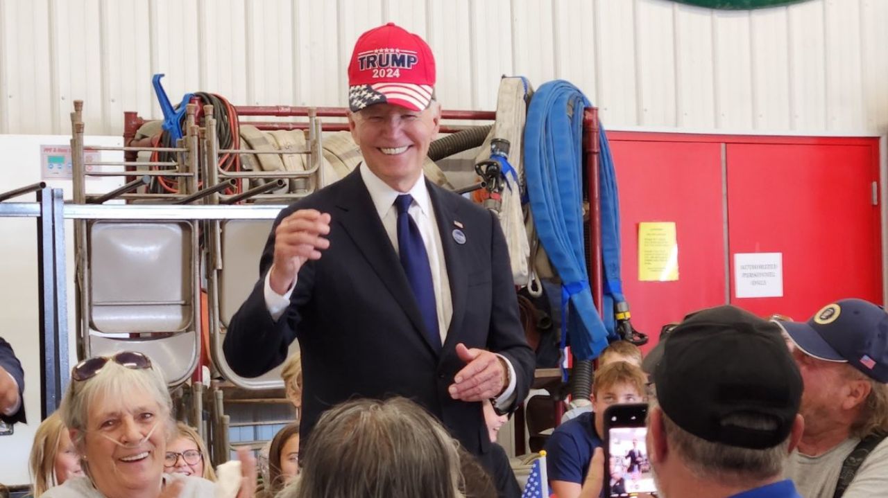 O presidente dos Estados Unidos, Joe Biden, usando um boné do ex-presidente Donald Trump, sorrindo