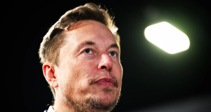 Elon Musk em close, sério, olhando para cima
