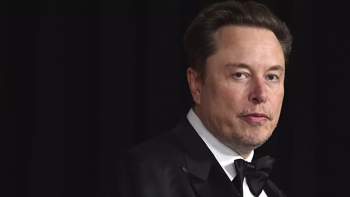 Elon Musk de roupa preta, olhando pra frente com expressão séria