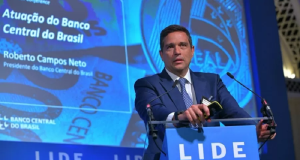 O presidente do Banco Central, Roberto Campos Neto, discursando, sério, em pé, sem olhar para a câmera