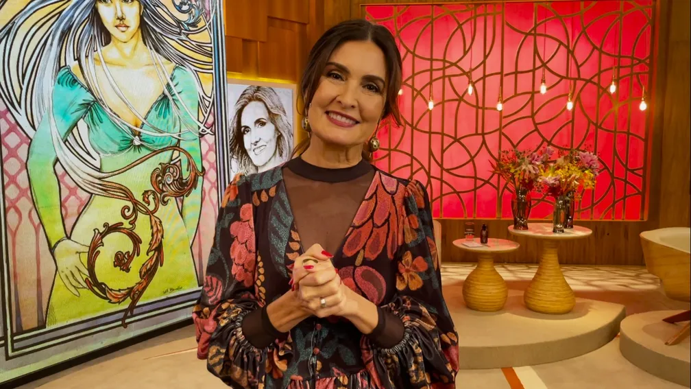 Fátima Bernardes no cenário do Encontro, de cabelo preso e roupa colorida, sorrindo