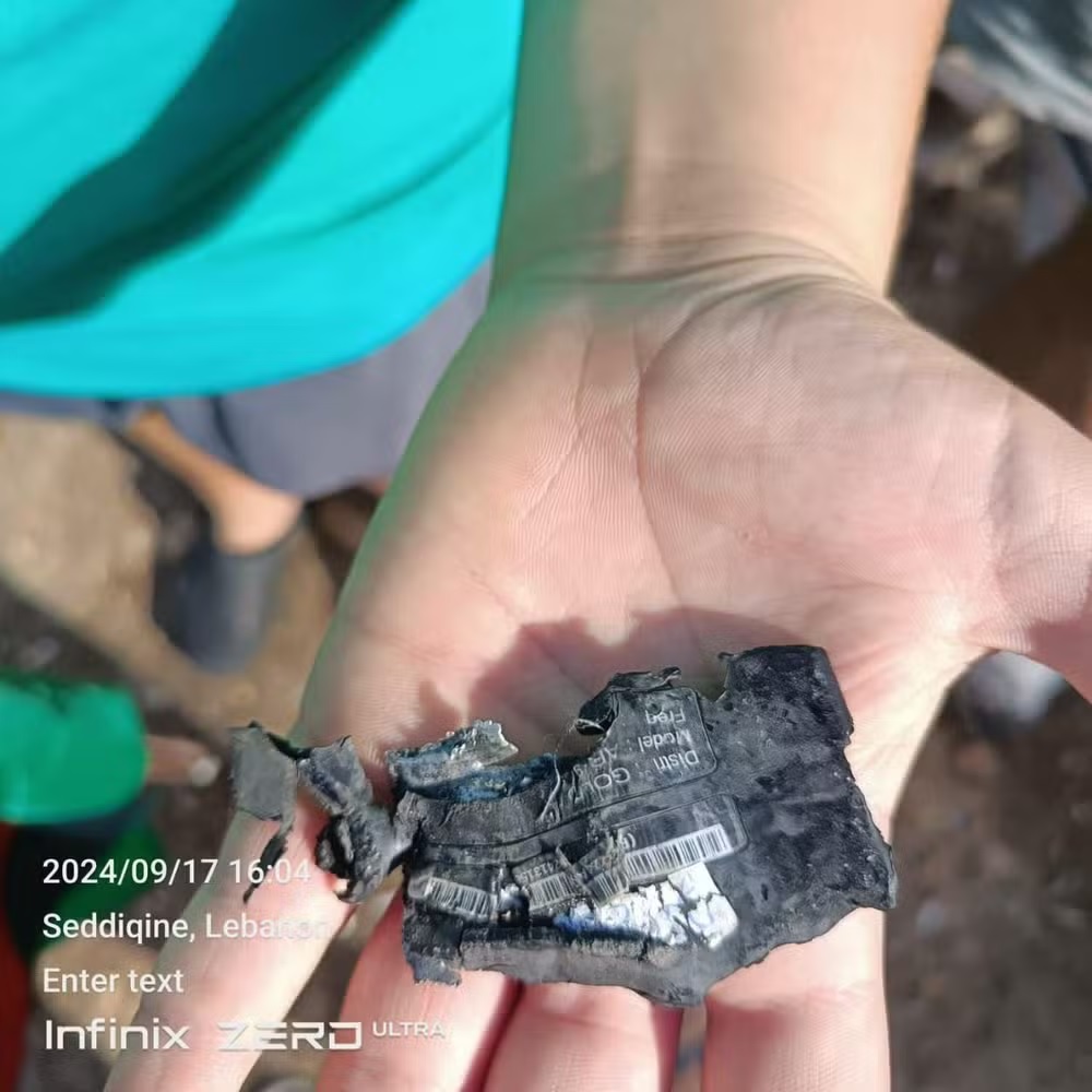 Homem com pager na mão após explosão