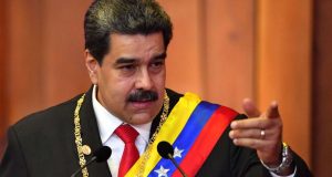 Nicolás Maduro falando e apontando, sem olhar para a câmera, com faixa presidencial