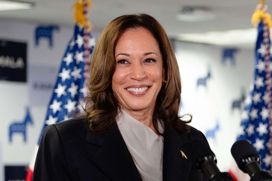Kamala Harris sorrindo, olhando para o lado