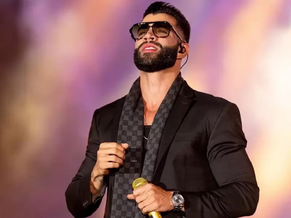 Gusttavo Lima de óculos e roupa preta, olhando para cima