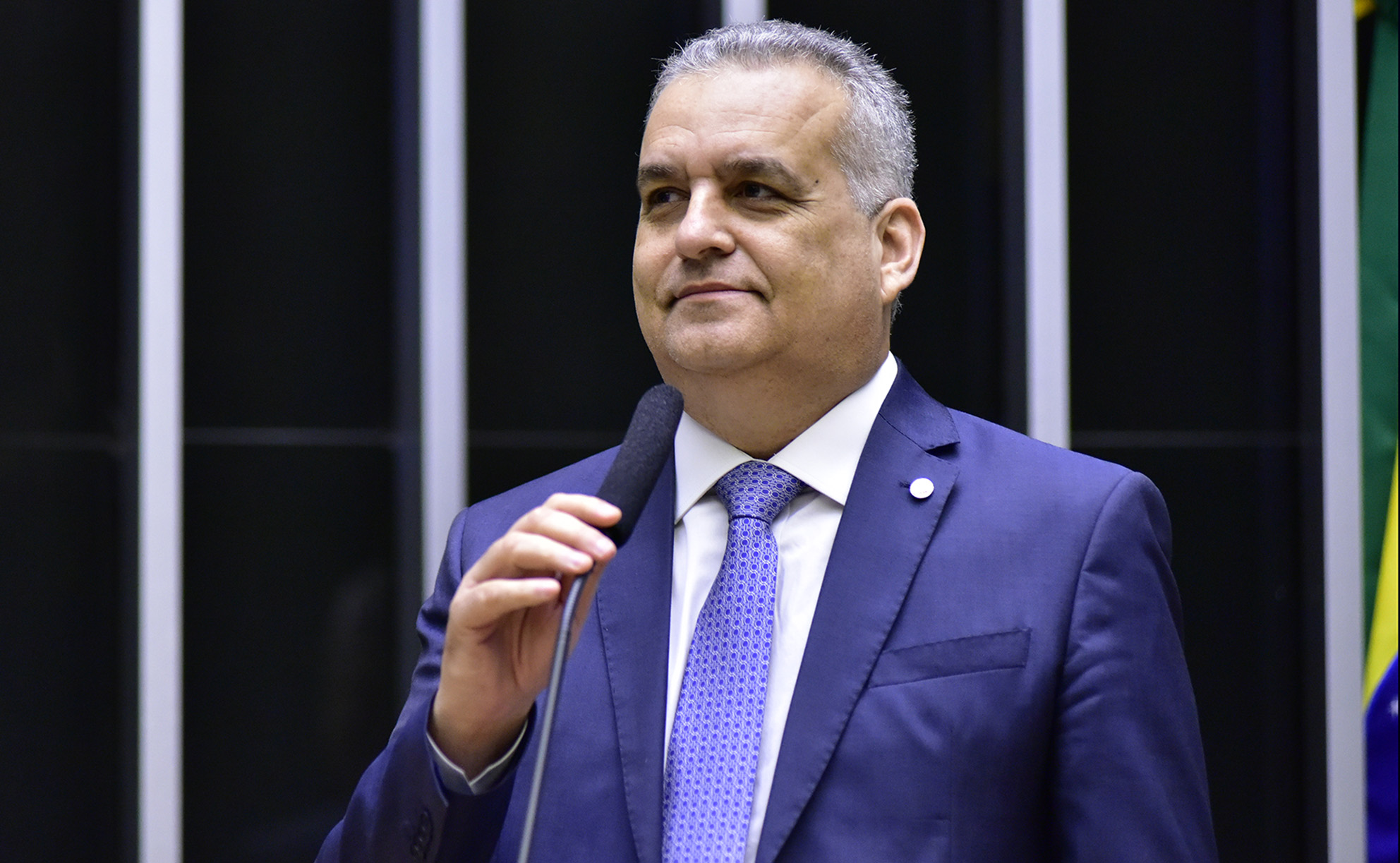 deputado Alfredo Gaspar (União-AL) segurando microfone, sorrindo de maneira tímida, sem olhar para a câmera