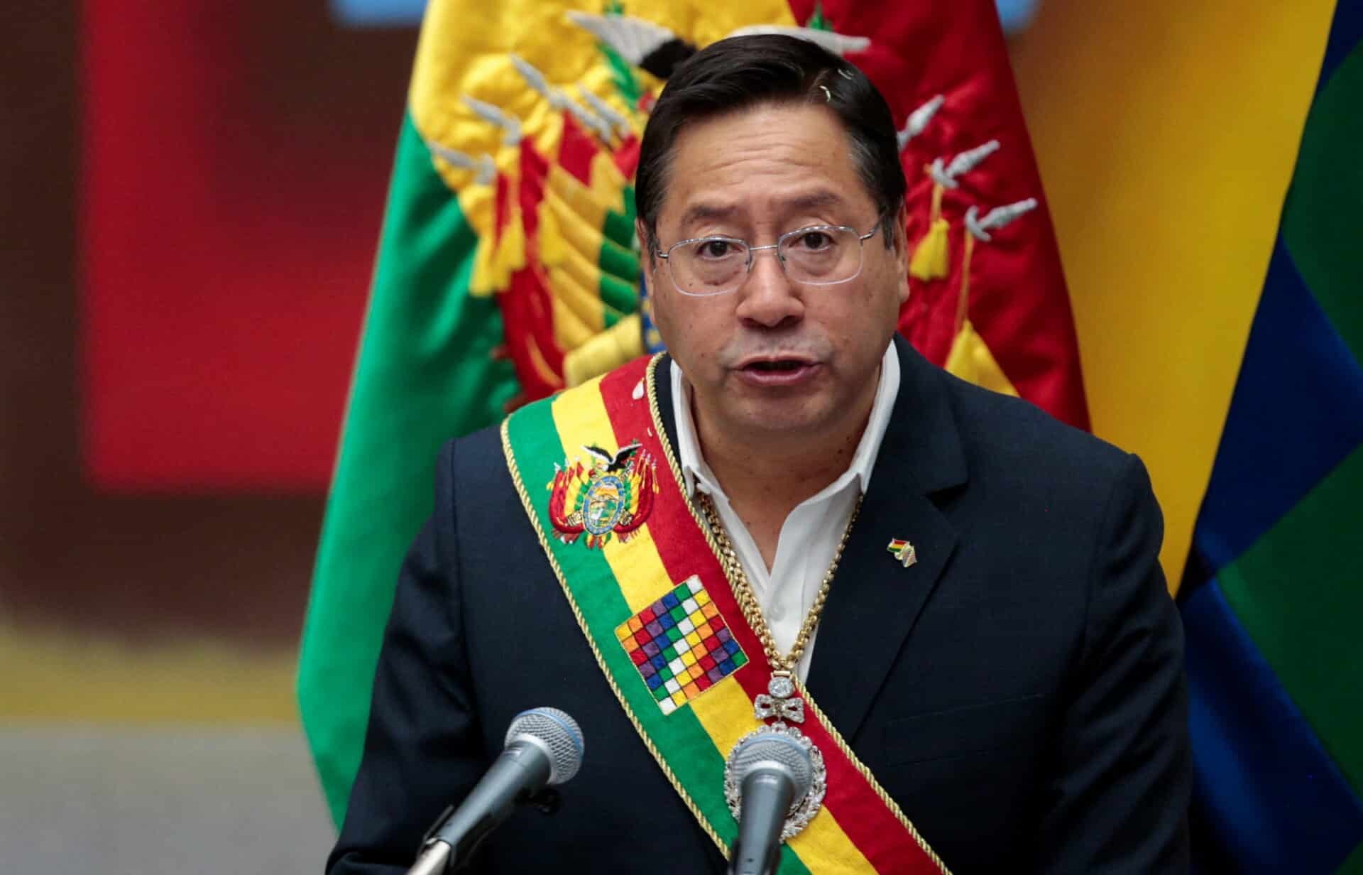 Luis Arce com faixa presidencial da Bolívia, falando com expressão séria