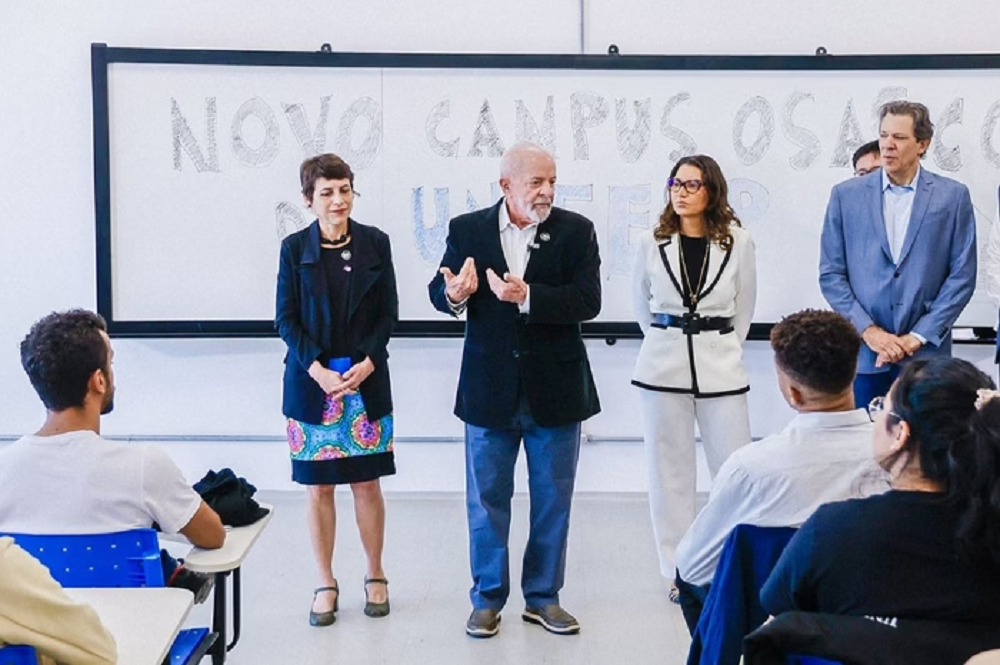 Lula, Janja e Haddad discursando em pé em sala de aula