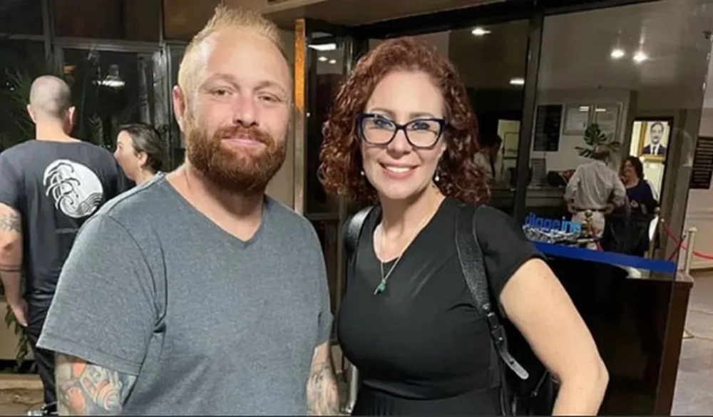Walter Delgatti Neto e Carla Zambelli posando lado a lado para foto, ela sorrindo