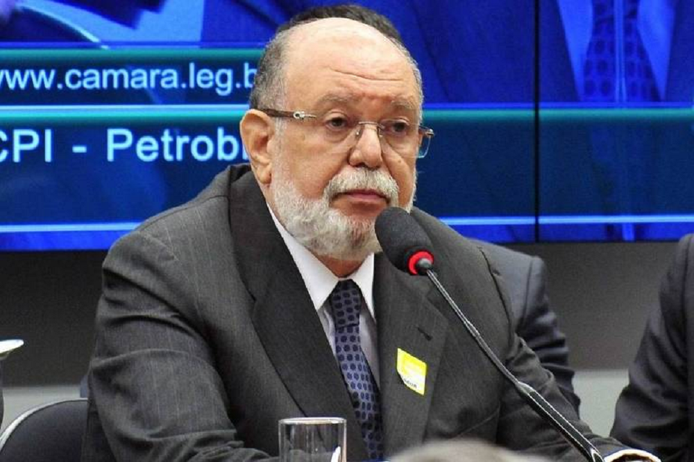 Léo Pinheiro sério, perto de microfone, sem olhar para a câmera