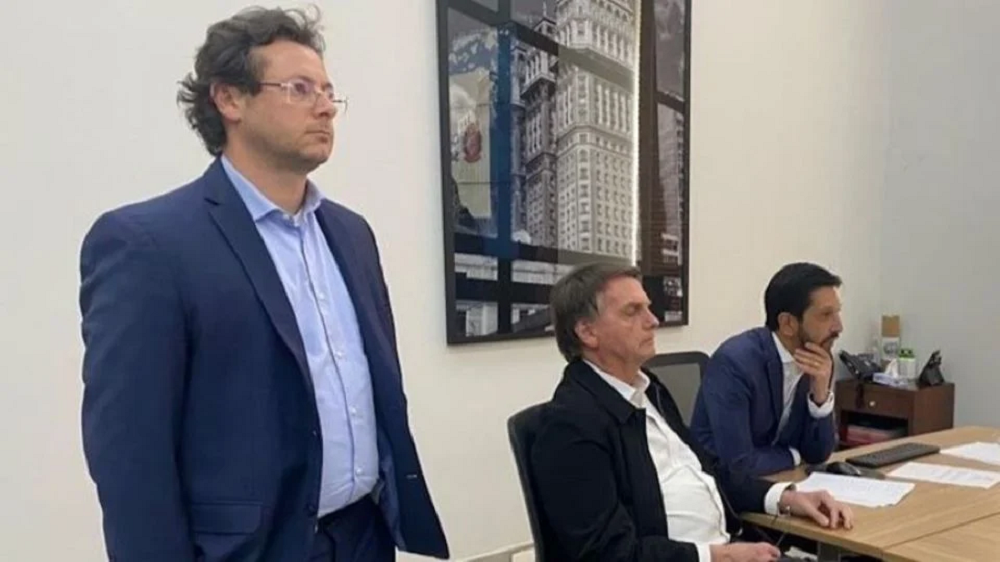 Fabio Wajngarten, com Jair Bolsonaro (aparentemente dormindo) e Ricardo Nunes