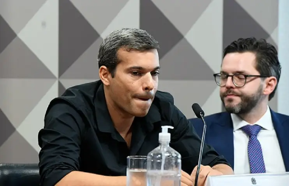 Bruno Tolentino de camisa social preta, sem olhar para a câmera, com expressão de desânimo
