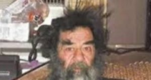 Saddam Hussein com expressão assustada, despenteado