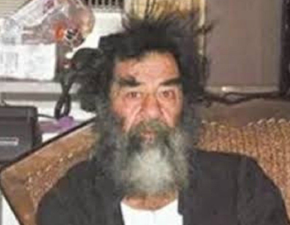 Saddam Hussein com expressão assustada, despenteado